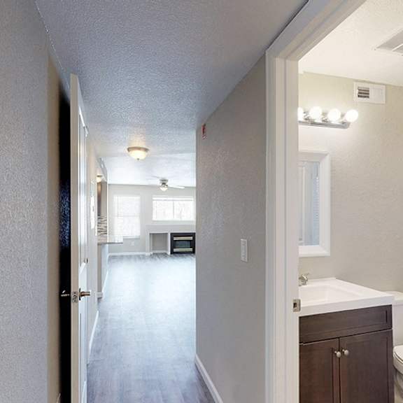 a long hallway with a bathroom at the end.