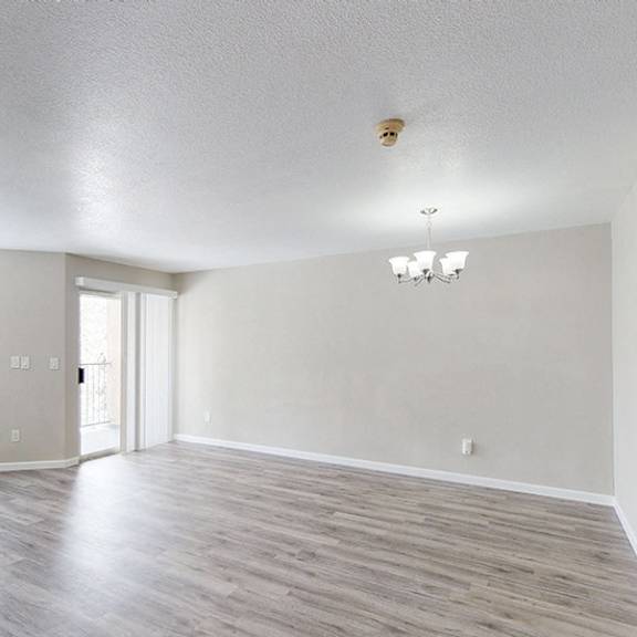 a spacious room with a fireplace and a ceiling fan.