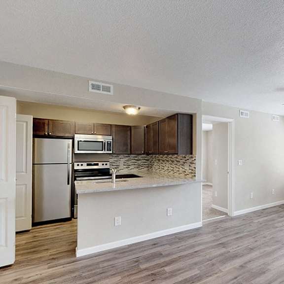 a kitchen with a refrigerator, microwave, and oven.