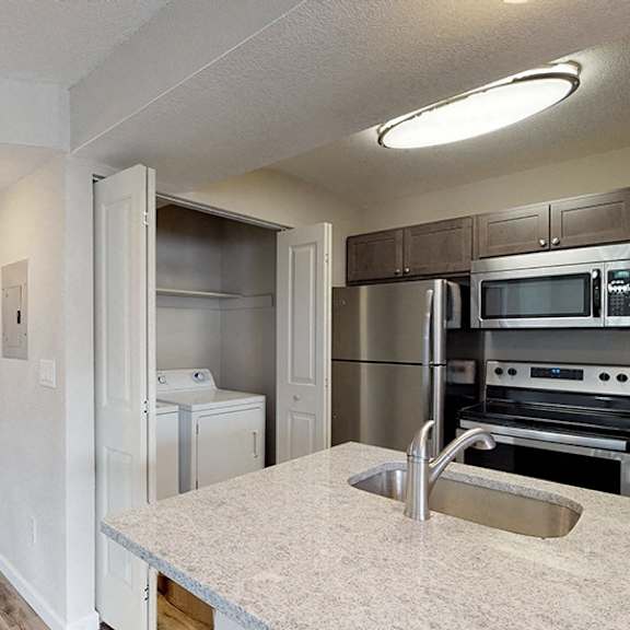 a kitchen with a sink, stove, and oven.