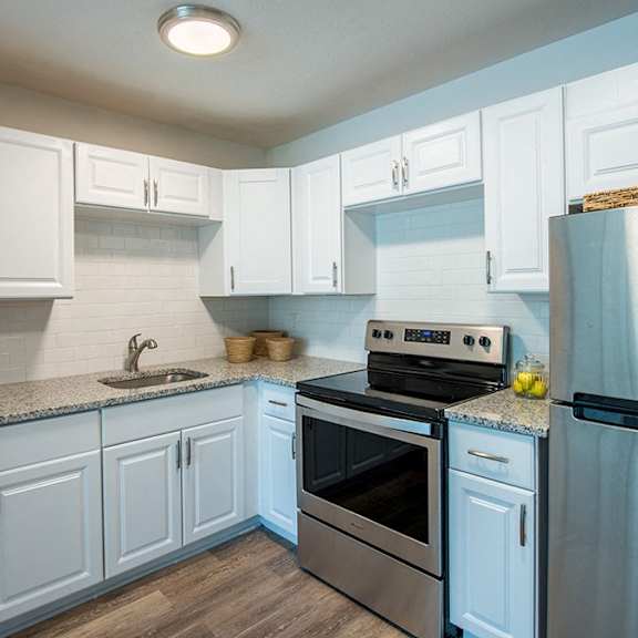 a kitchen with white cabinets and a stainless steel refrigerator.