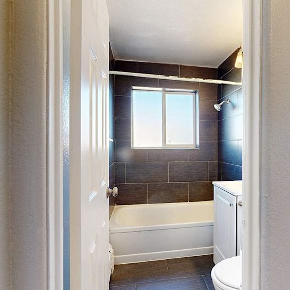 a bathroom with a tub, toilet, and sink.