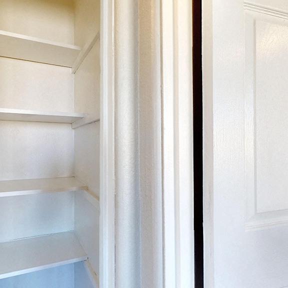 empty white shelves in a white door.