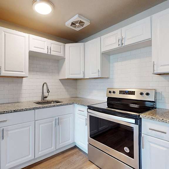 a kitchen with white cabinets and a stainless steel refrigerator.