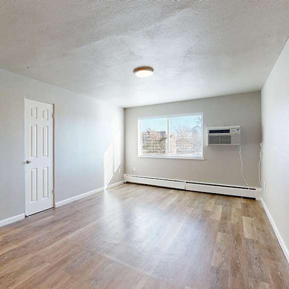 a room with wooden floors and white walls.