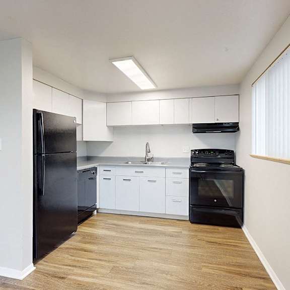 a kitchen with black appliances and white cabinets.