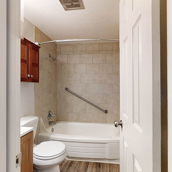 a white bathroom with a toilet, tub, and shower.