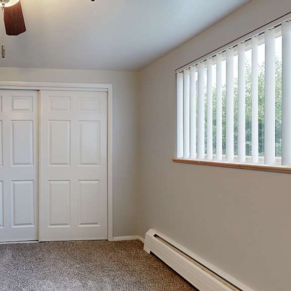 a room with two doors and a window with blinds.