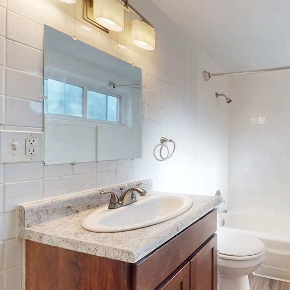 a bathroom with a white tub and a white sink.