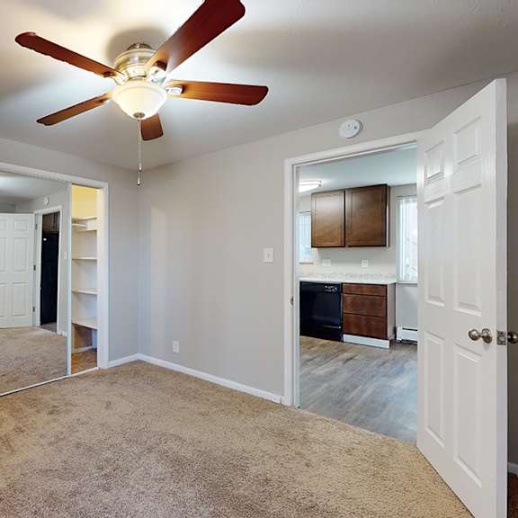 a room with a ceiling fan and carpeted floor.