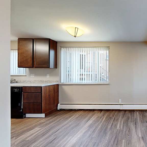 a room with wooden floors and a window with blinds.
