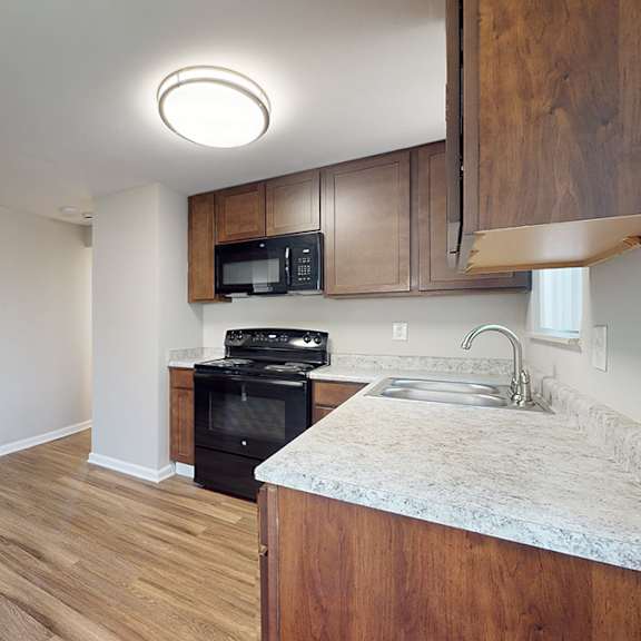 a kitchen with a black oven and microwave built into the cabinetry.