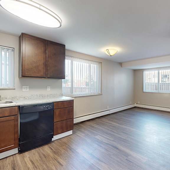 a kitchen with a black fridge and wooden cabinets.