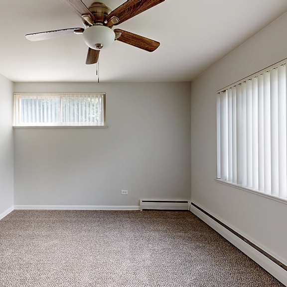 a room with a ceiling fan and a window with blinds.