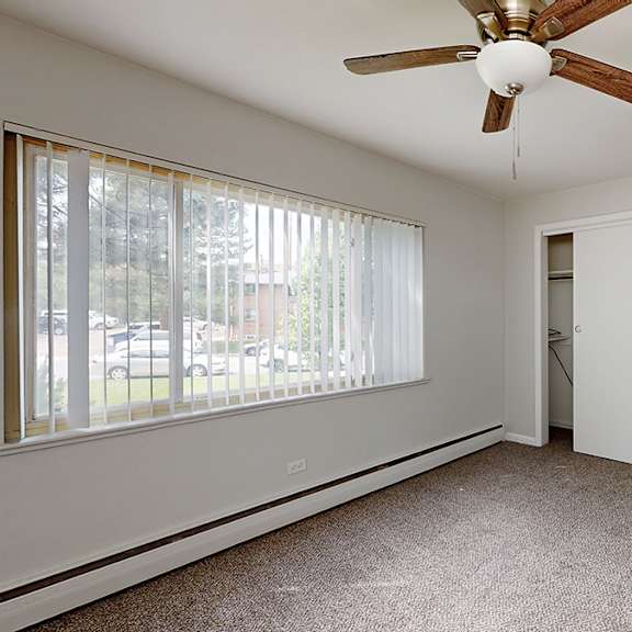 a room with a ceiling fan and carpeted floor.