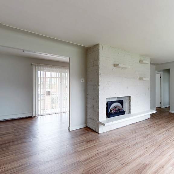 a room with a fireplace and wood flooring.