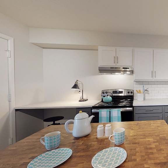 a kitchen with a wooden table and blue and white cups.