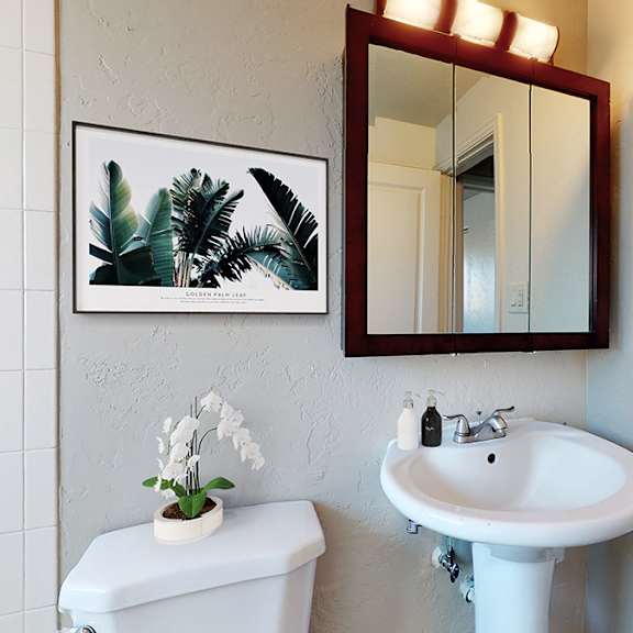 a white toilet sits next to a white sink in a bathroom.
