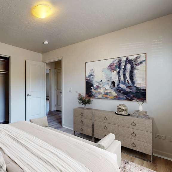 a white couch sits in a living room with a painting on the wall.