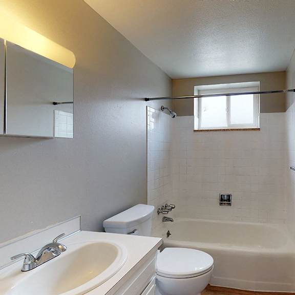 a white bathroom with a toilet, sink, and bathtub.