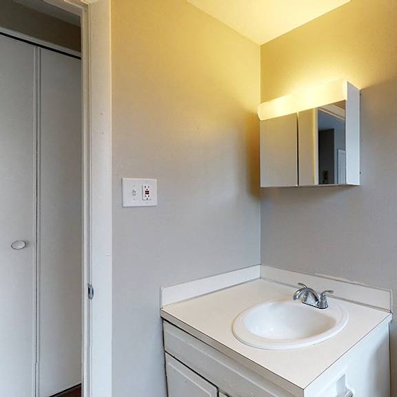 a bathroom with a sink, mirror, and toilet.