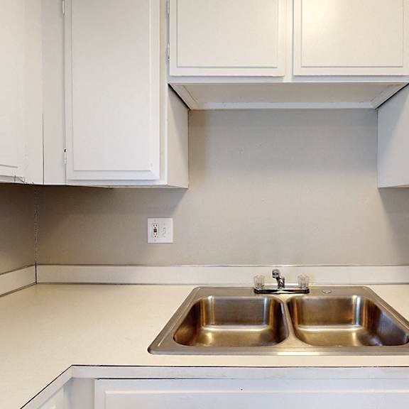 a kitchen with a double sink and white cabinets.