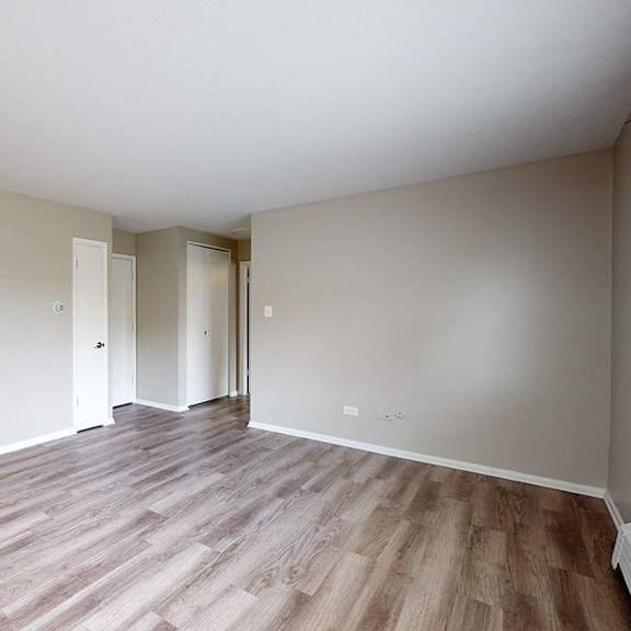 a room with wooden flooring and white walls.