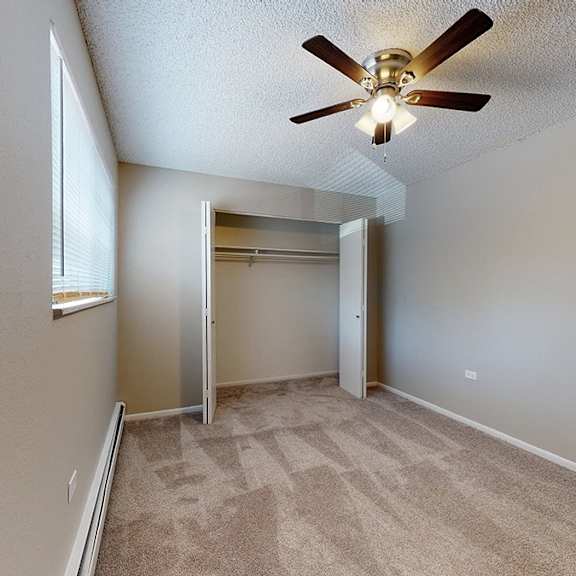 a room with a ceiling fan and carpeted floor.