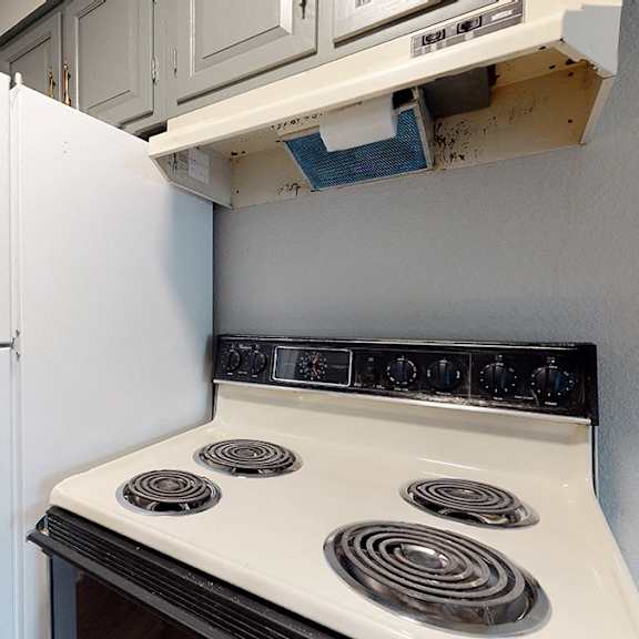 a white refrigerator is next to a stove in a kitchen.