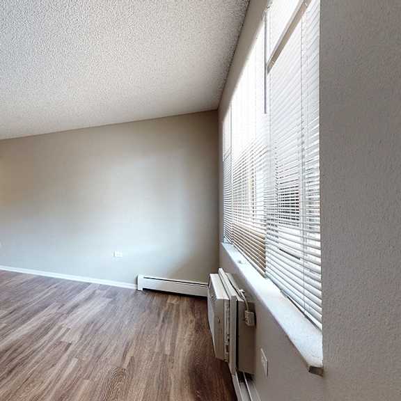 a room with a white door and a wooden floor.