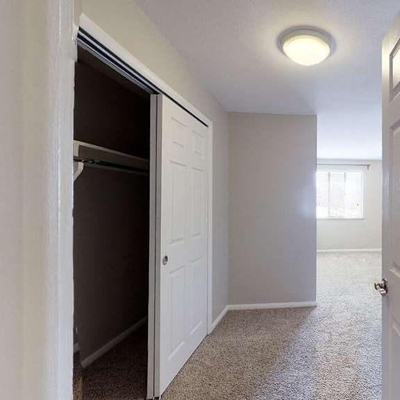 a hallway with a carpeted floor and white walls.