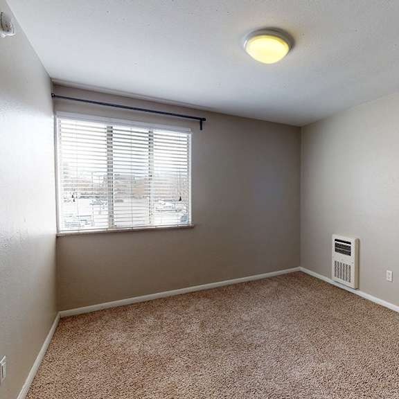 a room with a window and a carpeted floor.
