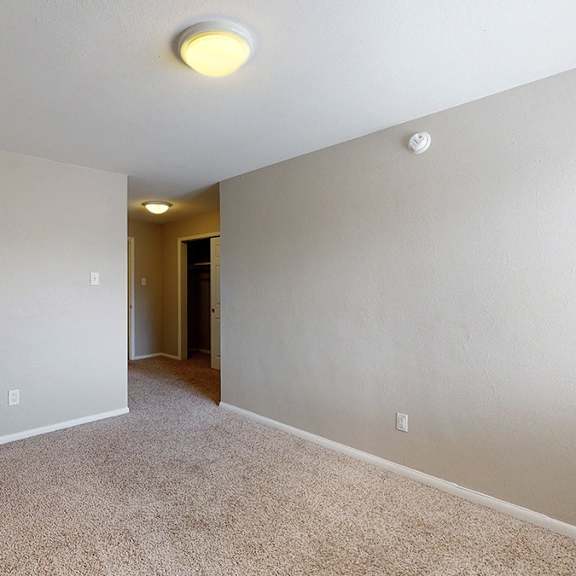 a room with a carpeted floor and a doorway leading to another room.