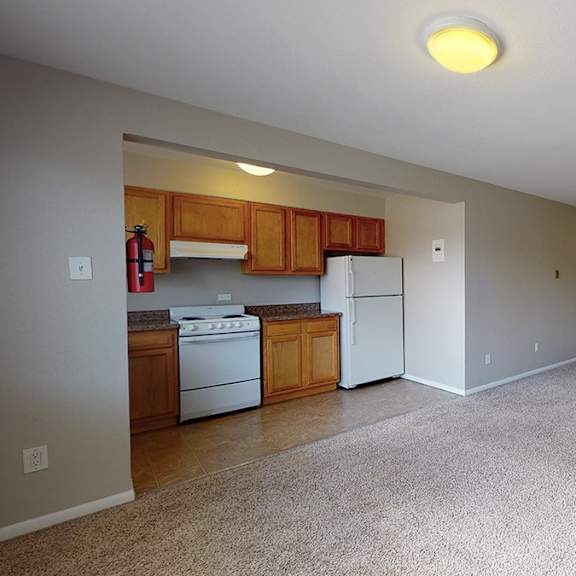 a kitchen with white appliances and wooden cabinets.