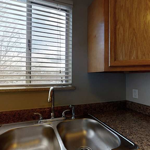 a kitchen with a sink and wooden cabinets.