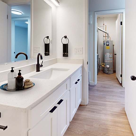 a bathroom with a white sink and a white counter top.
