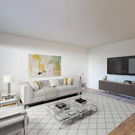 a living room with a white couch, a coffee table, and a television.