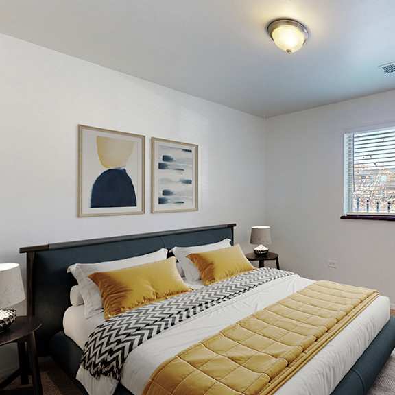 a bedroom with a bed, nightstand, and window.