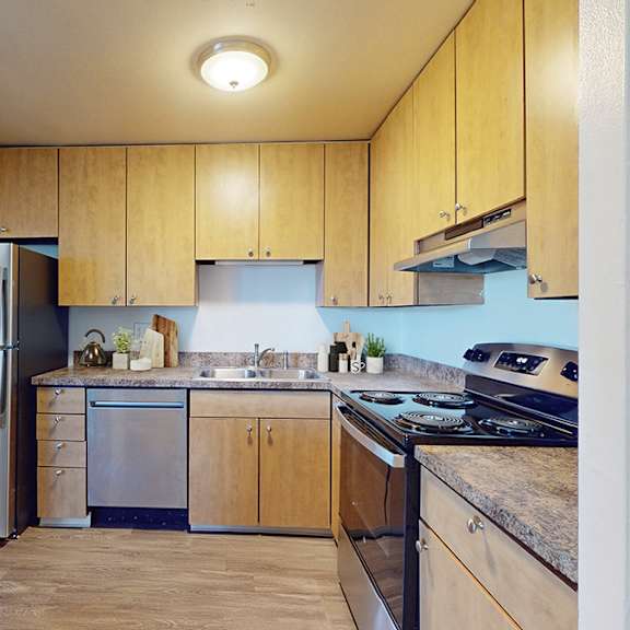 a kitchen with wooden cabinets and a stainless steel refrigerator.