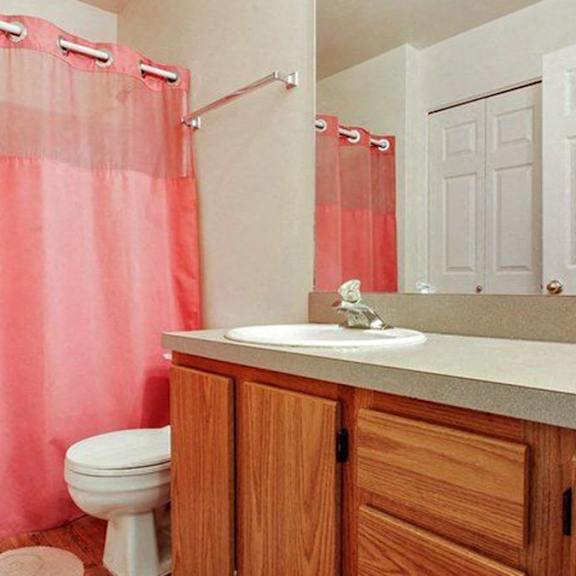 a bathroom with a toilet, sink, and shower curtain.