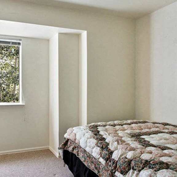 a bedroom with a bed, dresser, and window.