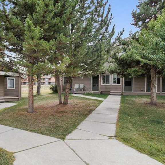 a row of houses with a sidewalk in between.