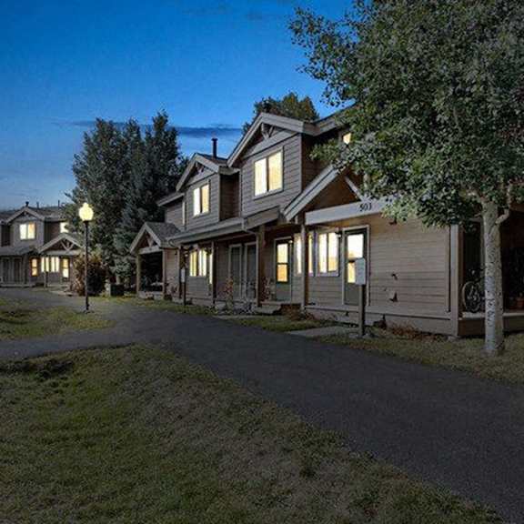 a row of houses with lights on at night.