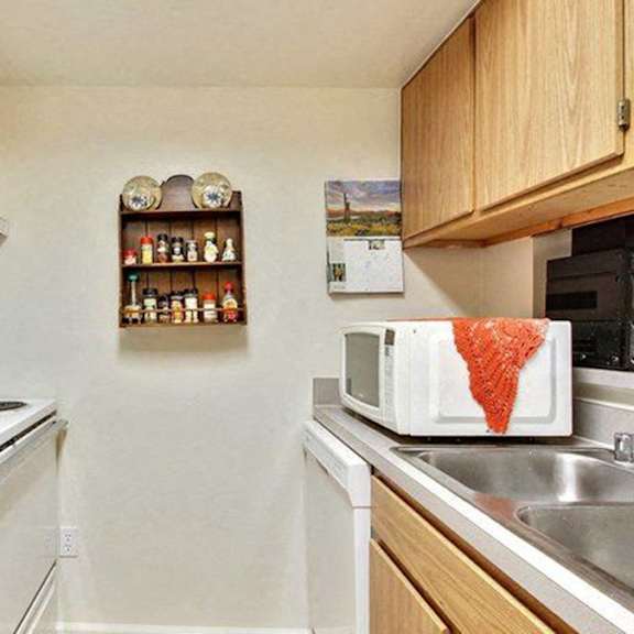 a kitchen with white appliances and wooden cabinets.