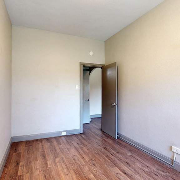 a room with wooden floors and a white door.