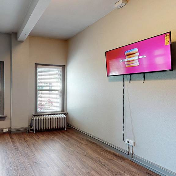 a room with a wooden floor and a window with blinds.