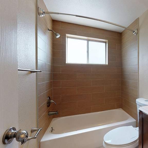 a bathroom with a tub, toilet, and sink.