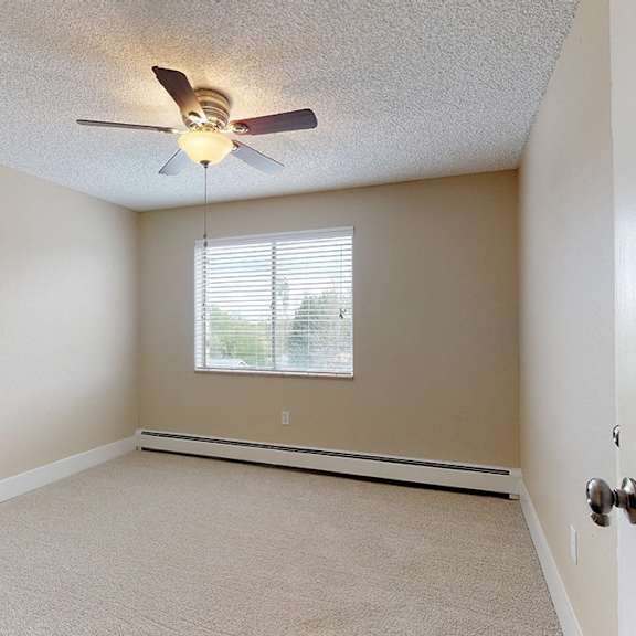 a room with a ceiling fan and a door.