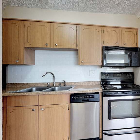 a kitchen with wooden cabinets and stainless steel appliances.