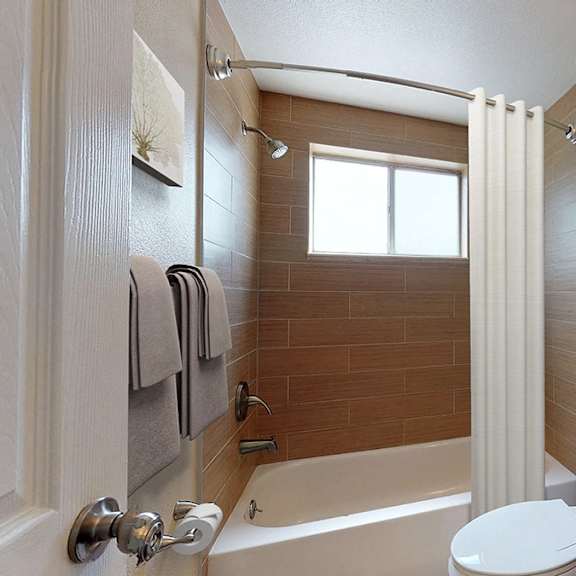 a bathroom with a white toilet, a white sink, a brown tub, and a mirror.